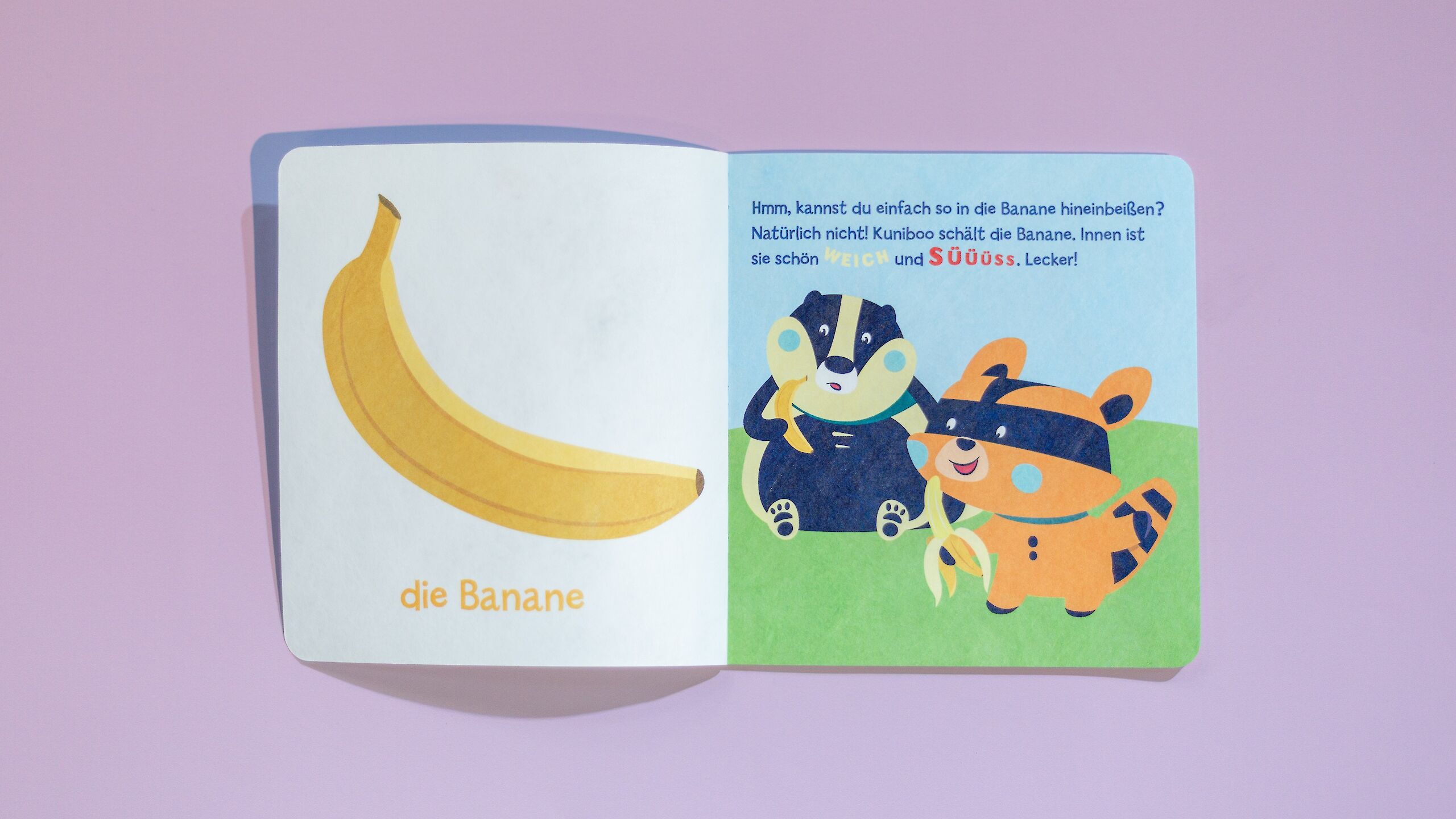 Das Bild zeigt ein aufgeschlagenes Baby Pixi. Links ist eine Banane mit der Überschrift „die Banane“. Rechts schält Kuniboo, der Waschbär, die Banane, während ein Freund daneben sitzt. Der Text erklärt, dass die Banane innen weich und süß ist.